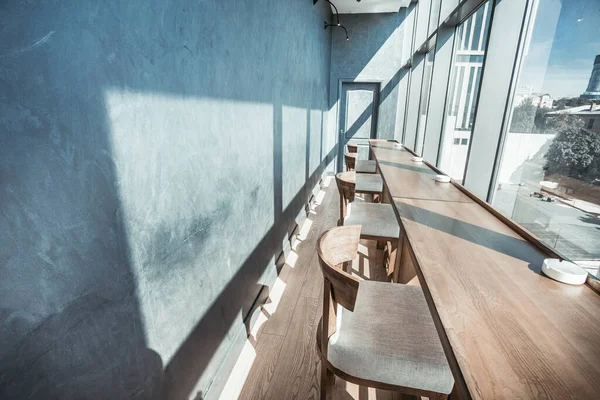 Desain teras cerah: perabotan kafe dengan kursi, meja di jendela dengan pemandangan perkotaan. Interior beige lembut — Stok Foto