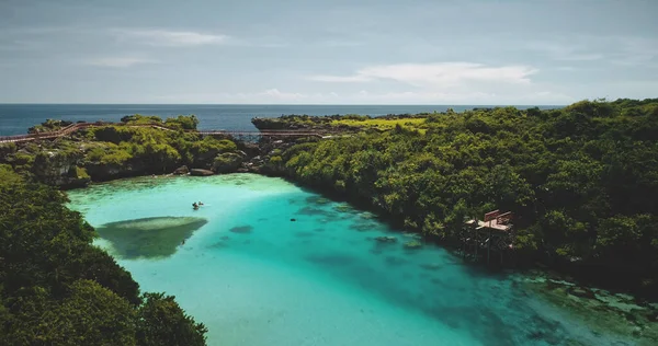 Turquoise lake with resting people aerial view. Tourists swimming at azure crystal clean lagoon — Stock Photo, Image