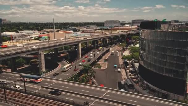 Autopista de la ciudad de Manila con coches y camiones en edificios modernos vista aérea. Paisaje urbano en la carretera de tráfico — Vídeo de stock