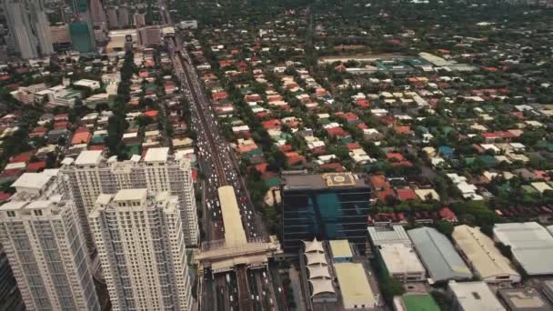 Modern skyscrapers and cottages at road, green trees in top down aerial view. Cityscape Manila town — Stock Video