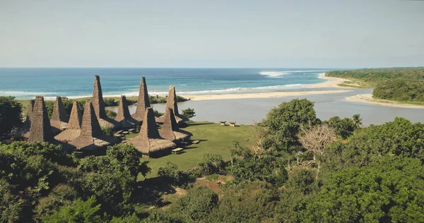 Aerial view of traditional village with ornately houses roof on sand beach sea shore, tropic forest — Stock Photo, Image