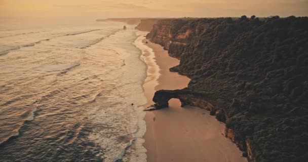 Movimento lento pôr-do-sol oceano paisagem marinha: ondas na parede de rocha na areia praia aérea. Ninguém paisagem natureza — Vídeo de Stock