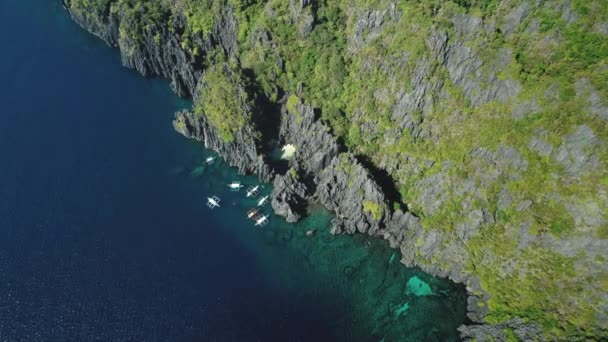 Barco de passageiros na costa do oceano penhasco na tranquila vista aérea da paisagem marítima. Majestosa natureza na ilha de rocha — Vídeo de Stock