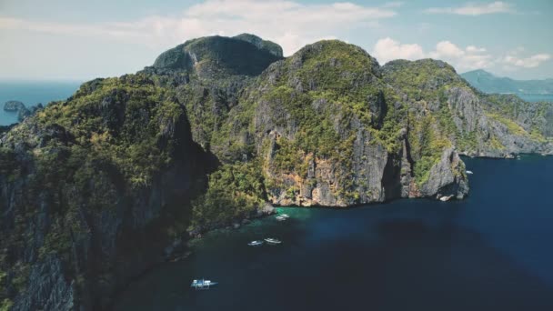 Vista aérea da ilha de montanha verde na água azul do oceano. Barcos de passageiros na costa do penhasco — Vídeo de Stock