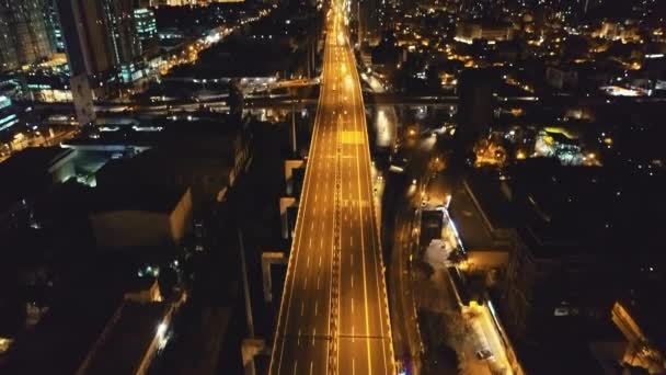 Carretera de tráfico nocturno de cámara lenta con coches de conducción en las luces de la linterna vista aérea. Ciudad en la oscuridad — Vídeos de Stock