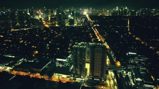 Slow motion luchtfoto Manilla stadsgezicht 's nachts verlichte straten: wolkenkrabbers, auto' s rijden snelweg — Stockvideo