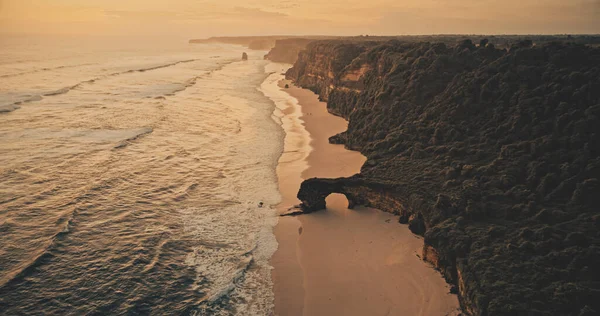 Atardecer océano paisaje marino con olas en la pared de roca en la playa de arena vista aérea. Nadie paisaje de la naturaleza — Foto de Stock