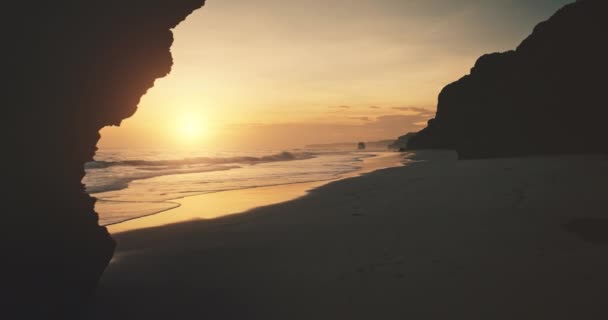 Spowolniony zachód słońca z gigantycznej dziury na ścianie klifu widok z powietrza. Letnia przyroda na piaszczystej plaży, zachód słońca — Wideo stockowe