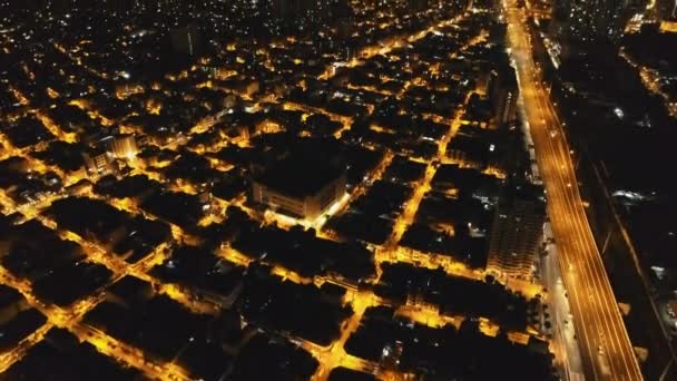 Calles nocturnas iluminadas en la antena de Manila. Edificios modernos, rascacielos, autopista en el paisaje urbano — Vídeo de stock