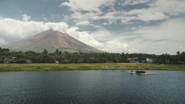 Volcan Mayon au bord du lac aérien. Touriste au bateau naviguer vers la côte d'herbe verte à Philippines île — Video