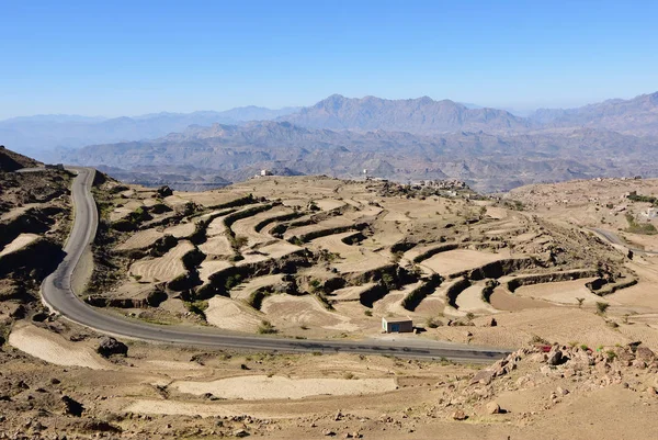Countryside landscape of Yemen. Tar road and rocks cut by agricultural fields