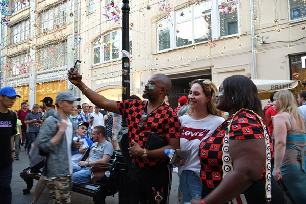 Moskova, Rusya - 23 Haziran 2018: Nijeryalı futbol fanatiği bir selfie Rus kız fan Moskova sokaklarında ile alır. Moskova, Dünya Kupası, dünya 2018 Nikolskaya sokaklarda yürürken yurt dışında futbol taraftarları