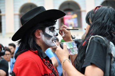 Moscow, Rusya Federasyonu - 29 Haziran 2018: Kız katılımcı şeker kafatası makyaj yüzündeki Dia de los Muertos Meksika Karnaval sırasında bir adam yapar. Ölülerin günü
