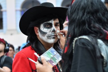 Moscow, Rusya Federasyonu - 29 Haziran 2018: Kız katılımcı şeker kafatası makyaj yüzündeki Dia de los Muertos Meksika Karnaval sırasında bir adam yapar. Ölülerin günü