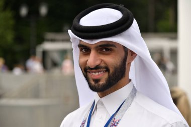 Moscow, Rusya Federasyonu - 14 Temmuz 2018: Geleneksel giysiler içinde Katar adam kamera ve gülümsüyor, futbol stadyumu içinde belgili tanımlık geçmiş görünüyor. Katar Rusya 2022'sonraki Dünya Kupası ev sahipliği ardılı