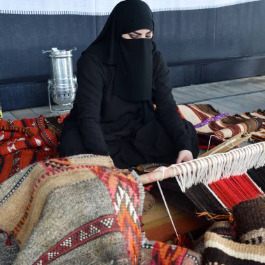 Moscow, Rusya Federasyonu - 14 Temmuz 2018: Genç bir Arap kadın kimden Katar bir geleneksel sadu dokuma yapar. 