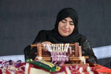 Moscow, Rusya Federasyonu - 14 Temmuz 2018: Arap kadın kıdemli bir geleneksel sadu dokuma yapar. Katar