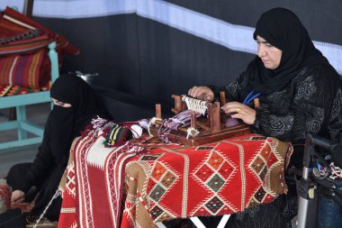 Moscow, Rusya Federasyonu - 14 Temmuz 2018: Üst düzey ve genç Arap kadın bir geleneksel sadu dokuma yapmak. Katar