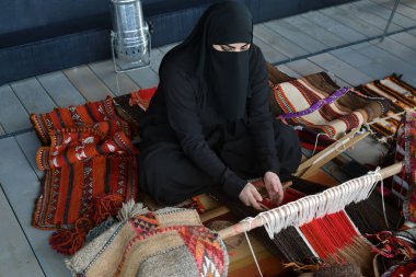 Moscow, Rusya Federasyonu - 14 Temmuz 2018: Genç bir Arap kadın kimden Katar bir geleneksel sadu dokuma yapar. 