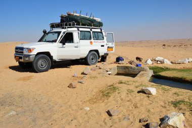 Sahara, Mısır - 26 Aralık 2008: Off-road araç su baharda Ain Khadra veya Ain el Wadi oasis yakınındaki. Aşırı çöl safari Mısır'daki yerel turistik cazibe biridir