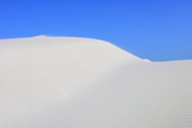 Gün batımında Aomak sahilinde büyük beyaz kum tepeleri, Socotra Adası, Yemen. Aomak sahilinin koruma alanı, Aden Körfezi, Arap Denizi, eşsiz biyolojik çeşitliliğin merkezi.