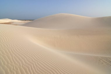 Gün batımında Aomak sahilinde büyük beyaz kum tepeleri, Socotra Adası, Yemen. Aomak sahilinin koruma alanı, Aden Körfezi, Arap Denizi, eşsiz biyolojik çeşitliliğin merkezi.