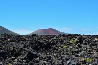 Lanzarote kara, donmuş volkanik çölünün ve arka planda bir yanardağın engin boşluğu ve yalnızlığı. Lanzarote, Kanarya Adası. İspanya