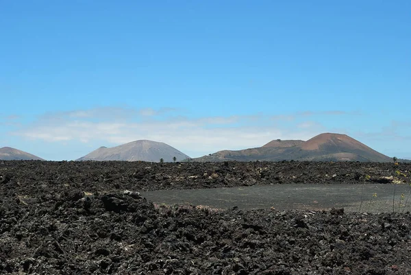 ランサローテ黒凍結溶岩火山砂漠や火山の広大な空虚さと孤独を背景にしています カナリア島ランサローテ島 スペイン — ストック写真