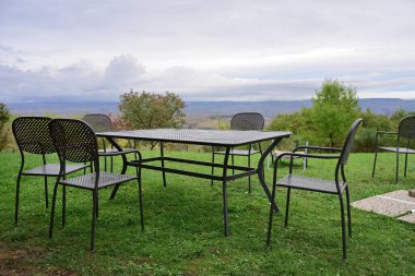 Piknik masası ve sandalyeler sonbaharda kır evinin bahçesindeki çimlerde.