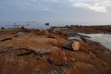 Güneş doğarken Beyaz Deniz 'in güzel manzarası. Onega Körfezi, Karelia, Rusya. Sular yükseldiğinde küçük bir bölge. Seçici odak