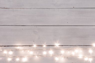 Beyaz ahşap arka plan kopya alanı için metin ile Noel ışıkları