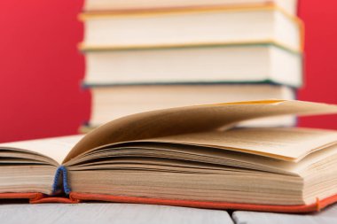 Eğitim ve bilgelik kavramı - ahşap masa üzerinde açık kitap, kırmızı arkaplan