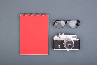 Gazeteci ya da blogger tablo sarmal boş defter, kalem ve gri arka plan, üstten görünüm üzerinde gözlük