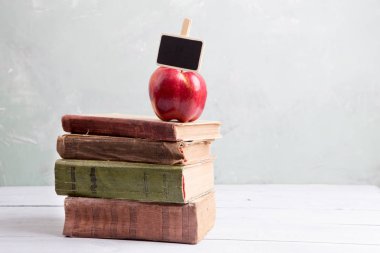 Küçük tabela ile masada kitapların bir yığınına elma