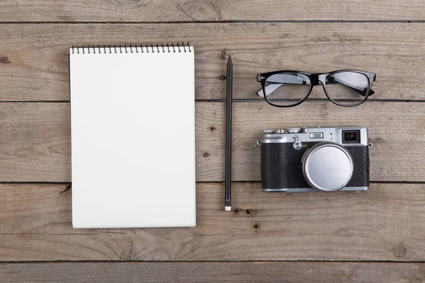木制桌子上的记事本 眼镜和照相机 — 图库照片