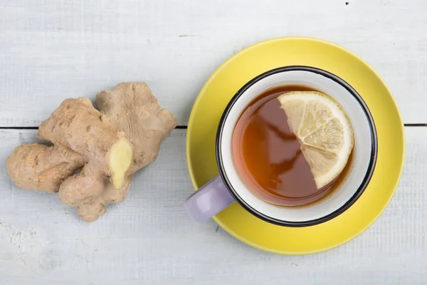 Ginger tea in a vintage cup on wooden background