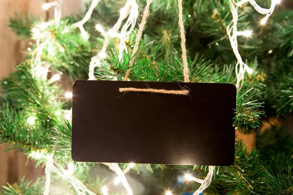 Blank tag on the Christmas tree with lights