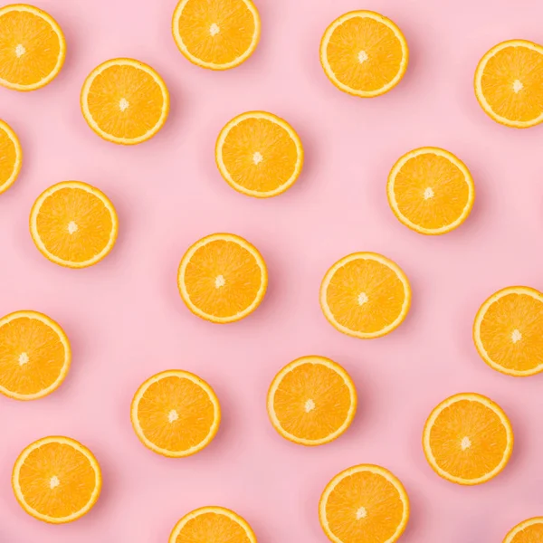 Colorful fruit pattern of fresh orange slices on pink background