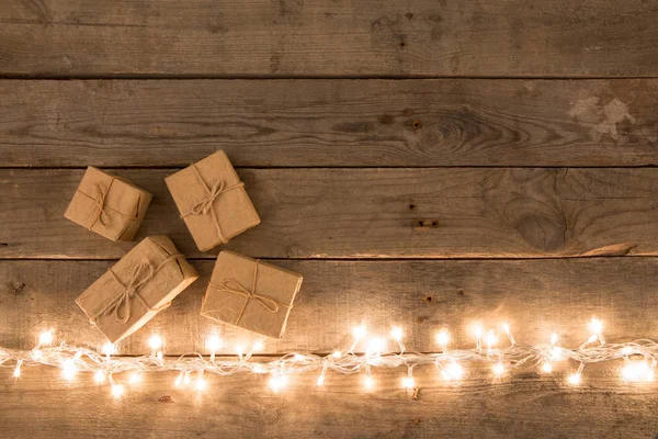 クリスマス プレゼントと木製の背景のライト — ストック写真