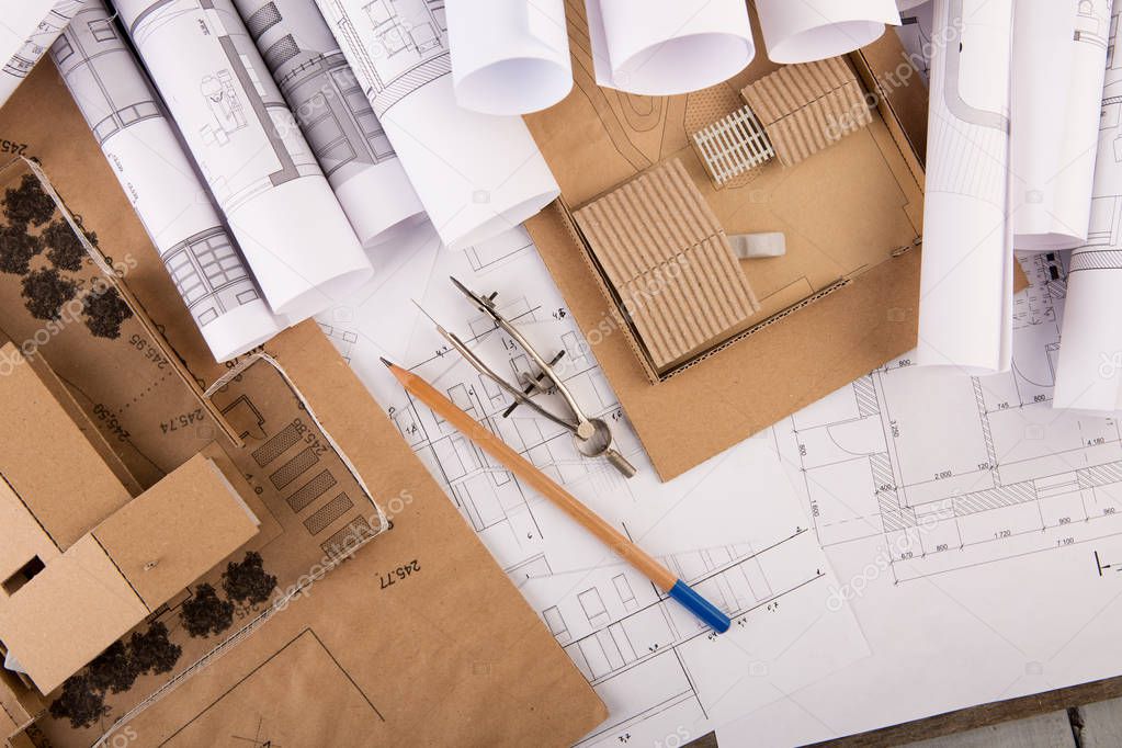 Workplace of architect - construction drawings, scale model of a house and tools