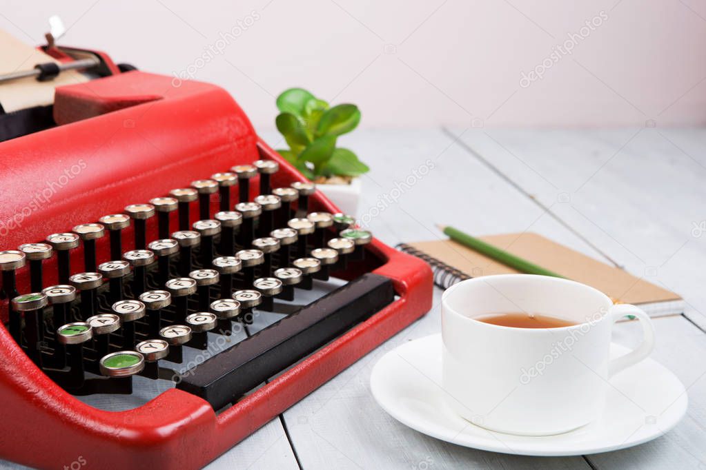 Writer or journalist workplace - vintage red typewriter on the white wooden desk