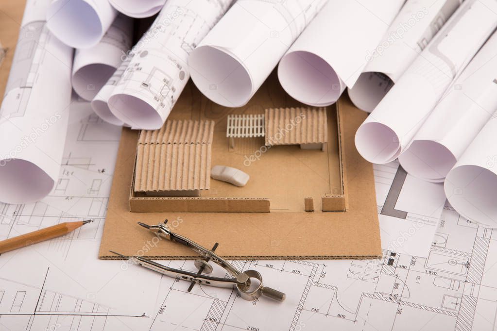 Workplace of architect - construction drawings, scale model of a house and tools