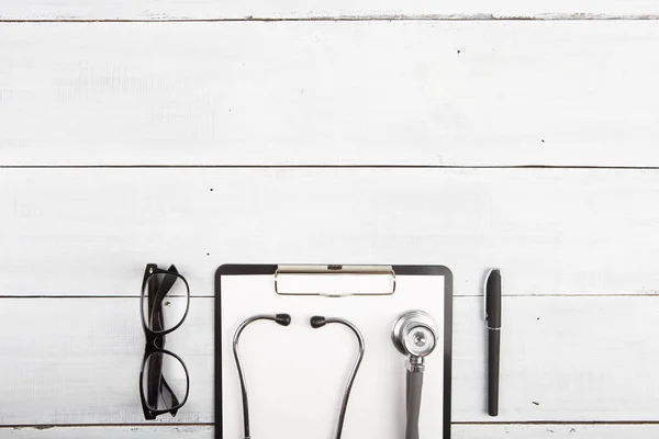 Pracoviště lékaře - stetoskop, lékařská schránka, brýle — Stock fotografie