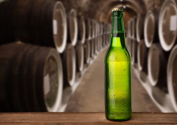 Botella de cerveza húmeda fría en el sótano con barriles vintage — Foto de Stock