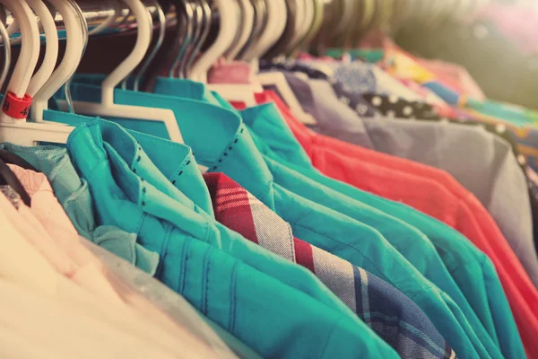 Kläder hänger på hyllan i butiken Royaltyfria Stockfoton