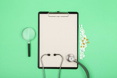 Doktor işyeri - tıbbi tablet, steteskop, haplar ve büyüteç