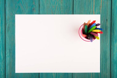 renkli boya kalemi ve masanın üstüne boş kağıt