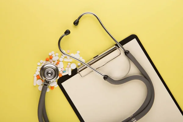 Lékařské pracoviště - lékařská tableta, stetoskop, pilulky a lupa — Stock fotografie