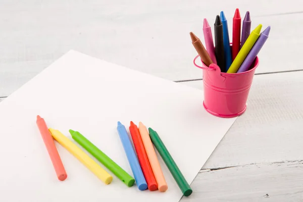 Färgglada kritor och blankt papper på skrivbordet — Stockfoto