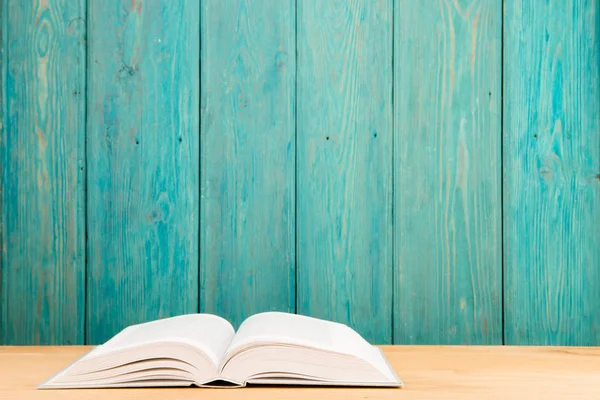 Masanın üzerinde açık bir kitap var.